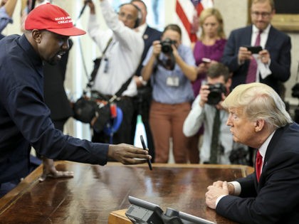 WASHINGTON, DC - OCTOBER 11: (AFP OUT) Rapper Kanye West , left, shows a picture of a plane on a phone to U.S. President Donald Trump during a meeting in the Oval office of the White House on October 11, 2018 in Washington, DC. (Photo by Oliver Contreras - Pool/Getty …