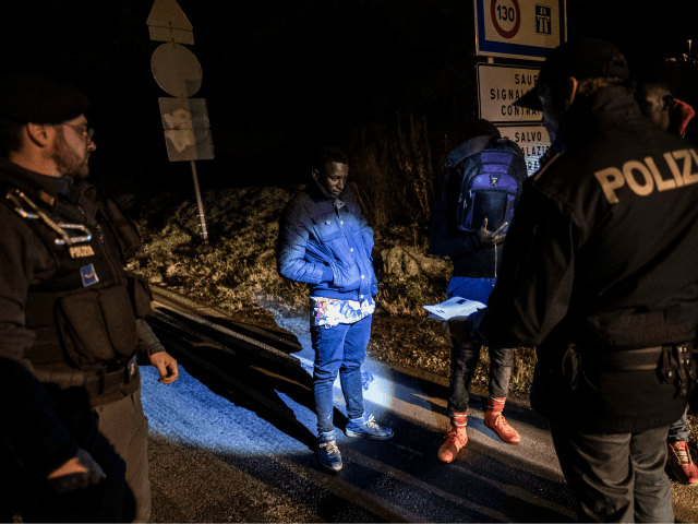 TOPSHOT - Italian police officers (L and R) newly dispatched at the border, check the pape