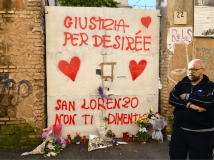 A resident stands by the entrance of a sequestered derelict building in the San Lorenzo district of Rome on October 24, 2018, a week after a female teenager was found dead in the building. - Italy's Interior minister Matteo Salvini paid a visit to the neighborhood on October 24, a …