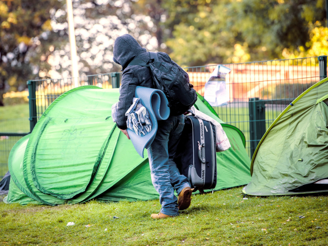 A man moves out his belonging from the Maximilien park where refugees build an improvised