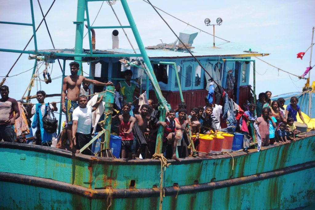 Migrants from Sri Lanka stand aboard a boat off the coast of Banda Aceh on June 13, 2016. Dozens of Sri Lankan immigrants bound for Australia were stranded off Aceh in northwest Indonesia after their boat broke down, local officials said on June 12. / AFP / CHAIDEER MAHYUDDIN (Photo credit should read CHAIDEER MAHYUDDIN/AFP/Getty Images)