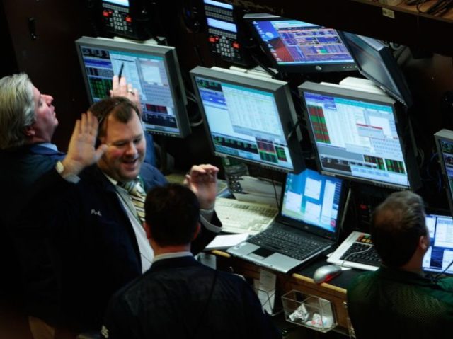 NEW YORK - OCTOBER 01: A trader smiles gestures another for a high-five on the floor of t