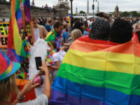 GettyImages-800558366 Activists wear rainbow flags as they take part in the Gay Pride parade in Paris on June 24, 2017. 2017 marks the 40th anniversary of the first Gay Pride March in the French capital. / AFP PHOTO / JACQUES DEMARTHON (Photo credit should read JACQUES DEMARTHON/AFP/Getty Images)