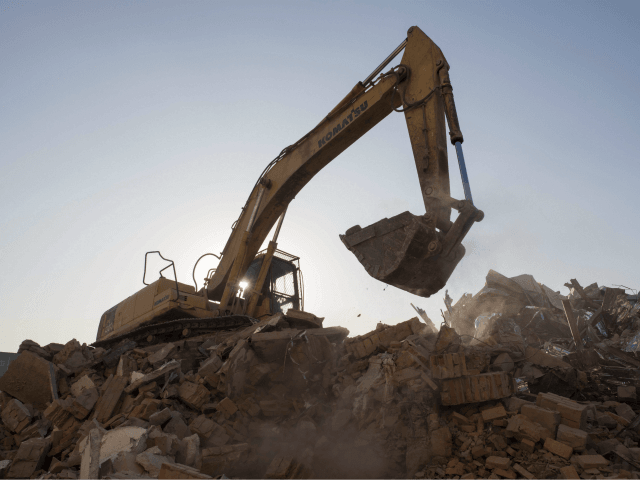 In this picture taken on December 8, 2017, a bulldozer clears debris from buildings demoli