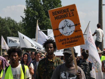 People take part in a "solidarity" march in support of migrants in Calais on July 7, 2018. The placard reads: "Welcome to migrants. Freedom of movement and settlement". - Several hundred people took part in the march, organised by French charity L'Auberge des migrants and supported by numerous NGOs, which …