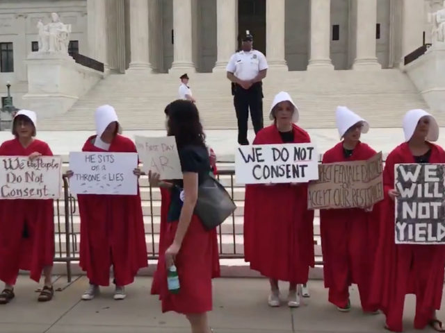 Protesters greeted newly confirmed Supreme Court Justice Brett Kavanaugh for his first day of work on Tuesday dressed as characters from the TV show The Handmaid's Tale.