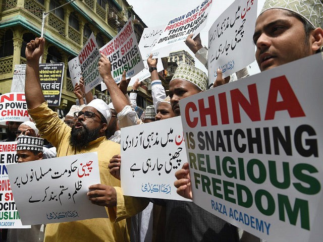 Indian Muslims hold placards during a protest against the Chinese government over the dete