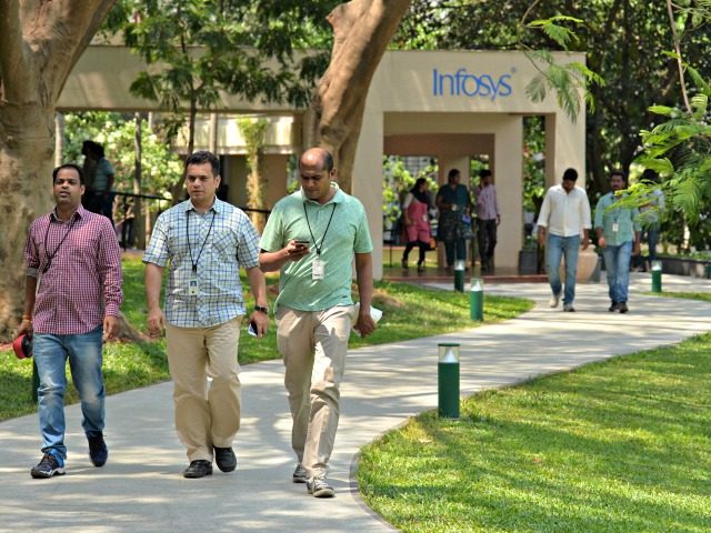 Employees of Infosys Technologies Limited walk in the campus of the company's headquarters
