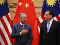 Mahathir-Mohamad-and-Li-Keqiang-getty Malaysian Prime Minister Mahathir Mohamad (L) and his Chinese counterpart Li Keqiang chat during a signing ceremony at the Great Hall of the People (GHOP) in Beijing, China, 20 August 2018.(Photo by How Hwee Young - Pool/Getty Images)