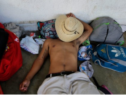 A Central American migrant traveling with a caravan to the U.S. rests upon arrival to Huix