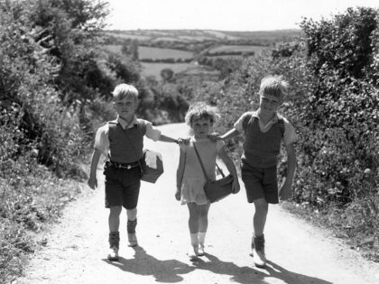 Evacuee children from London, on their way to school in Devon, World War II 1940. The children are (left to right) Ronald (7), Iris (4) and David Blackie (8), of Campbell Buildings in Lower Marsh, near Waterloo Station, London. They are staying in a farmhouse with a Mrs Shillabeer. (Photo …