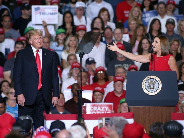 Rep. Martha McSally, R-Ariz, gestures to President Donald Trump during a rally at the International Air Response facility on October 19, 2018 in Mesa, Arizona. McSally is the republican candidate for the U.S. Senate seat to be vacated by Sen. Jeff Flake. President Trump is holding rallies in Arizona, Montana …