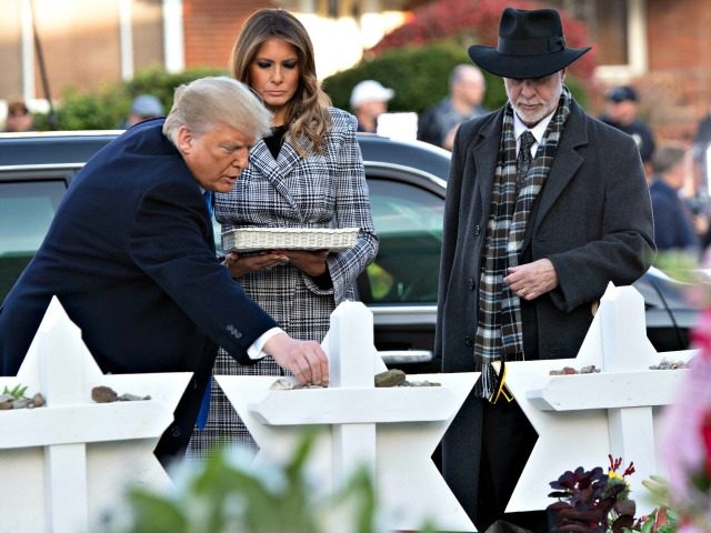 President Trump and first lady Melania Trump, alongside Rabbi Jeffrey Myers, place stones
