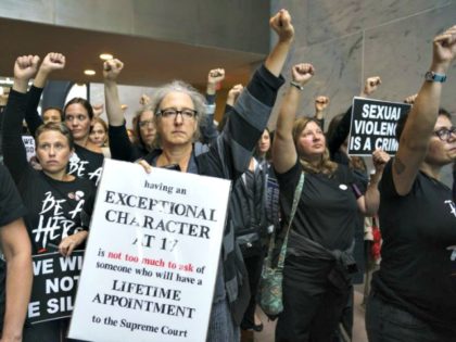 Protesters opposed to Supreme Court nominee Brett Kavanaugh stand quietly with fists raised in the Hart Senate Office Building on Capitol Hill in Washington, D.C., on Sept. 24, 2018.