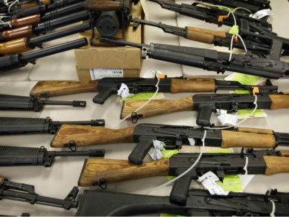 In this Jan. 25, 2011, file photo, a cache of seized weapons that were to be smuggled into Mexico is displayed in Phoenix. Among the thousands of immigrants who have been coming across the U.S.-Mexico border in recent months, many are seeking to escape gang and drug violence raging in …