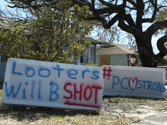 Signs reading, 'Looters Will B Shot' and '#PCStrong,' are seen written on mattress boxes i