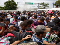 Mexican Federal Police spray tear gas during clashes with thousands of Central American migrants, at the border crossing in Ciudad Hidalgo, Mexico, Friday, Oct. 19, 2018. Central Americans traveling in a mass caravan broke through a Guatemalan border fence and streamed by the thousands toward Mexican territory, defying Mexican authorities' …