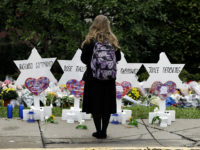mourner-stands-memorial-pittsburgh-synagogue-shooting-ap A person stands in front of Stars of David that are displayed in front of the Tree of Life Synagogue with the names of those killed in Saturday's deadly shooting in Pittsburgh, Monday, Oct. 29, 2018. (AP Photo/Matt Rourke)
