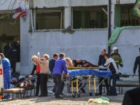 TOPSHOT - EDITORS NOTE: Graphic content / Rescuers carry an injured victim of a blast at at a college in the city of Kerch on October 17, 2018. - Thirteen people were killed and 50 more wounded, most of them teenagers, after a blast tore into a college canteen in …