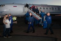 In this handout picture released by Russia's space agency Roscosmos, NASA astronaut Nick Hague and Russian cosmonaut Alexey Ovchinin are welcomed by family members and officials after landing at the Krayniy Airport in Baikonur, Kazakhstan
