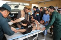 Afghan volunteers transport an injured man on a stretcher to a hospital following a bomb attack on an electino rally in Taloqan