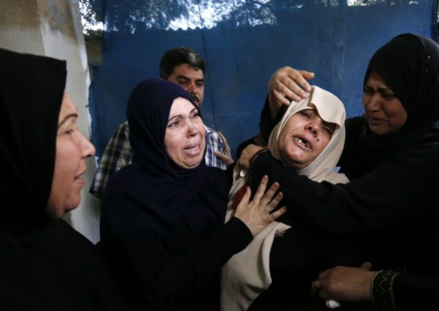 The mother (C) of Palestinian Ahmed al-Taweel, shot dead by Israeli troops during protests along the Gaza-Israel border, mourns at his funeral in central Gaza's Nuseirat camp on October 13, 2018 Thousands in Gaza mourn 7 killed in border clashes