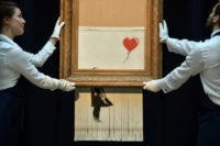 British street artist Banksy created an art world sensation by sending his painting through a shredder hidden in a frame moments after it sold at auction for £1,042,000 ($1.4 million, 1.2 million euros)