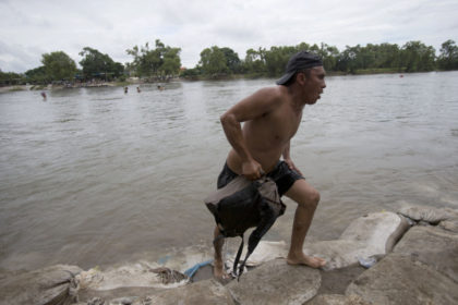 APTOPIX Central America Migrant Caravan A Central American migrant walks off the shore on the Mexican side of the Suchiate River after wading across, on the the border between Guatemala and Mexico, in Ciudad Hidalgo, Mexico, Saturday, Oct. 20, 2018. After Mexican authorities slowed access through the border bridge to a crawl, hundreds of migrants are boarding the rafts or wading across the river and crossing into Mexico illegally. (AP Photo/Moises Castillo) Migrant caravan swells to 5,000 resumes advance toward US