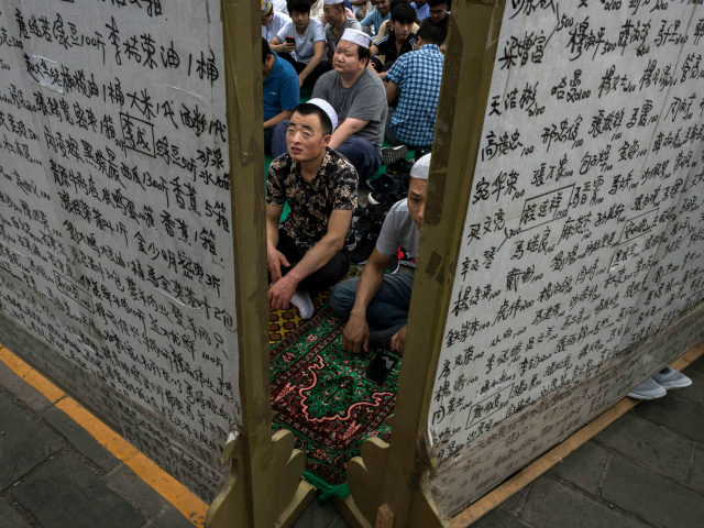 Chinese Hui Muslim men wait on a carpet before Eid al-Fitr prayers marking the end of the holy fasting month of Ramadan at the historic Niujie Mosque on June 16, 2018 in Beijing, China. Islam in China dates back to the 10th century as the legacy of Arab traders who …