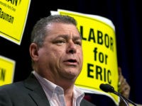 Eric-Bauman-Labor-for-Eric-sign-ap In this photo taken Saturday, May 20, 2017, Eric Bauman addresses the California Democratic Party Convention, in Sacramento, Calif. Bauman defeated Kimberly Ellis by a mere 62 votes out of nearly 3,000 cast, a razor-thin margin for a candidate who lined up support from most of the state's elected Democrats. …