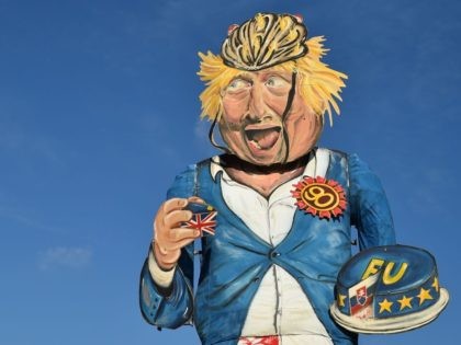 The Edenbridge Bonfire Society's 2018 'Celebrity Guy', former British foreign secretary Boris Johnson, created by artist Andrea Deans, is seen during the unveiling in Edenbridge, Southern England on October 31, 2018. - The giant effigy of Boris Johnson, depicted eating a piece of EU-themed cake wearing his trademark boarding shorts …