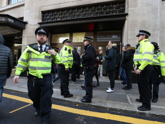 Police officers are seen outside the office building housing Sony Music's offices in