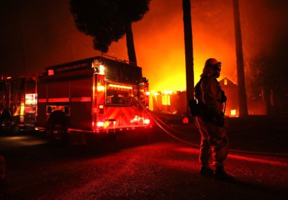 PARADISE, CA - NOVEMBER 08: Firefighters try to save a building as the Camp Fire moves thr