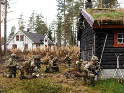 ELVAL, NORWAY - NOVEMBER 03: British soldiers from Anzio Company of the Duke of Lancaster Regiment take cover from enemy fire behind a log cabin, during the live exercise on November 3, 2018 in Elval, Norway. Over 40,000 participants from 31 nations are taking part in the NATO "Trident Juncture" …