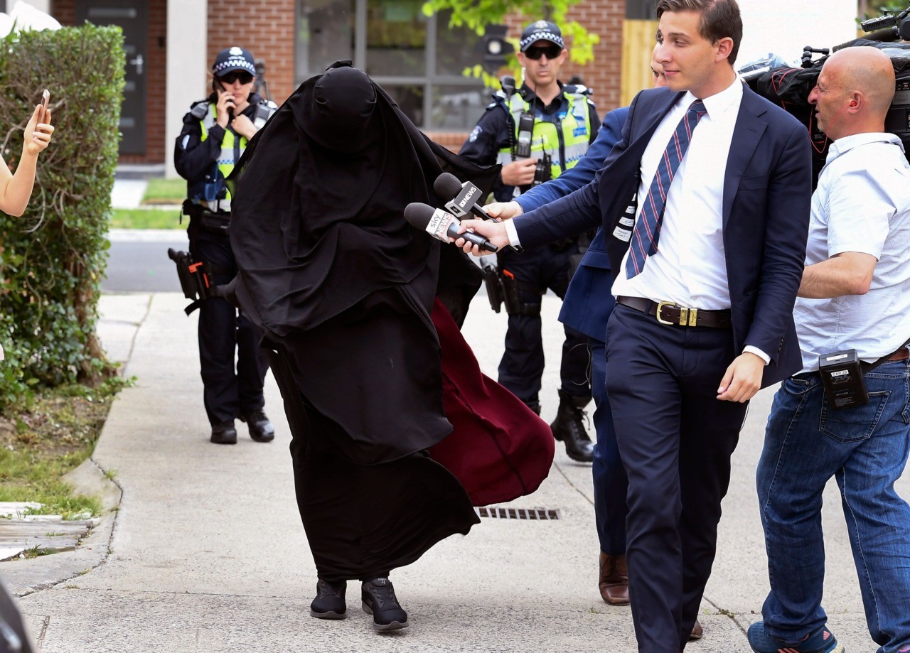 Journalists question a woman as she enters a house raided by police in the Melbourne suburb of Dallas on November 20, 2018. - Three men who allegedly plotted "chilling" terror attacks in Melbourne were arrested early November 20, less than two weeks after a stabbing rampage inspired by the Islamic State group left two dead in Australia's second largest city, police said. (Photo by William WEST / AFP) (Photo credit should read WILLIAM WEST/AFP/Getty Images)