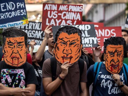 People holds caricatures of China's President Xi Jinping during a protest in Manila on Nov