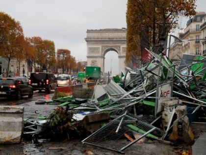 TOPSHOT - A picture taken on November 25, 2018 near the Arc de Triomphe on the Champs-Elysees avenue in Paris shows broken barriers a day after a rally by yellow vest (Gilets jaunes) protestors against rising oil prices and living costs. - Security forces in Paris fired tear gas and …