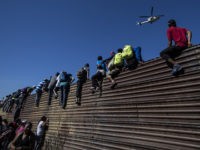 TOPSHOT-MEXICO-HONDURAS-US-MIGRATION TOPSHOT - A group of Central American migrants -mostly Hondurans- climb a metal barrier on the Mexico-US border near El Chaparral border crossing, in Tijuana, Baja California State, Mexico, on November 25, 2018. - US officials closed the San Ysidro crossing point in southern California on Sunday after hundreds of …