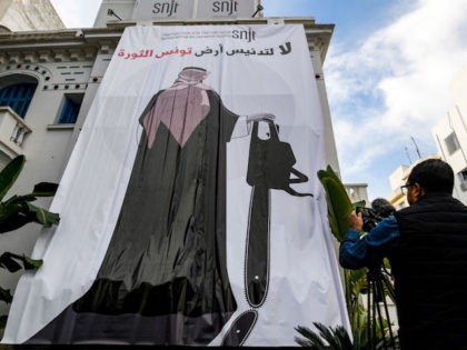 This picture taken on November 26, 2018 shows a giant banner hanging at the headquarters of Tunisia's Journalists Union in the capital Tunis depicting a cartoon of Saudi Crown Prince Mohammed bin Salman holding a chainsaw with a caption above reading in Arabic "no to the desecration of Tunisia, the …