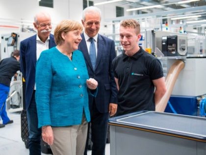 CEO of German carmaker Daimler and Mercedes-Benz, Dieter Zetsche (L), Saxony State Premier Stanislaw Tillich (3rdL) look as German Chancellor Angela Merkel talks to a trainee during a visit to the new plant of the ACCUMOTIVE company producing accumulators for cars in Kamenz, eastern Germany on May 22, 2017. Accumotive …