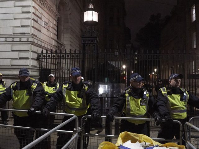 Police guard the entrance to Downing Street as anti-capitalist demonstrators march along W