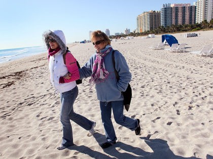 MIAMI BEACH, FL - JANUARY 11: Helena Anderson (L) and her mother Daniela Birska wear jackets as they walk on the beach on January 11, 2010 in Miami Beach, Florida. The National Weather Service said it recorded 36 degrees in Miami Monday morning, which beat the 82-year-old record of 37 …