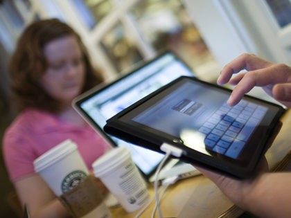 FORT WORTH, TEXAS - APRIL 3: Jamie Phelps, 29, syncs his newly purchased iPad while visiting a Starbucks Coffee with his wife, Ann Phelps, April 3, 2010 in Fort Worth, Texas. Debuting today, the much heralded iPad looks to be a bridge between a laptop and smartphone. (Photo by Tom …