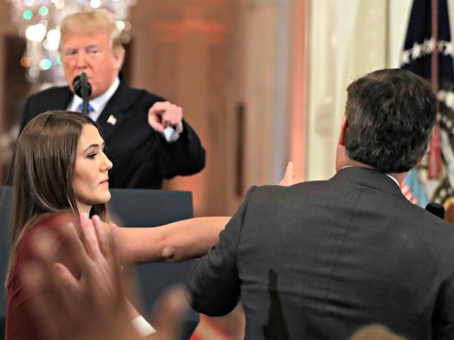 As President Donald Trump points to CNN's Jim Acosta, a White House aide takes the microph