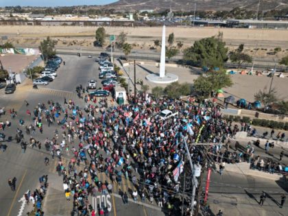 A group of migrants gather at the Chaparral border crossing in Tijuana, Mexico, Sunday, Nov. 25, 2018, as they try to pressure their way into the U.S. The mayor of Tijuana has declared a humanitarian crisis in his border city and says that he has asked the United Nations for …