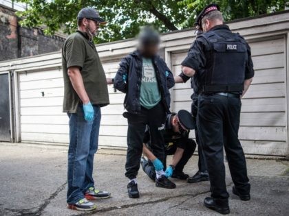 LONDON, ENGLAND - JULY 12: (EDITORS NOTE: Part of this image has been pixellated to obscure identity) A suspect is detained and searched by police officers after being arrested for alleged possession of a dangerous weapon near Elephant and Castle Station during Operation Sceptre on July 12, 2017 in London, …