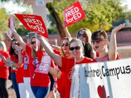 Teachers at Humphrey Elementary school participate in a state-wide walk-in prior to classes Wednesday, April 11, 2018, in Chandler, Ariz. Arizona teachers are demanding a 20 percent pay raise and more than $1 billion in new education funding. (AP Photo/Matt York)