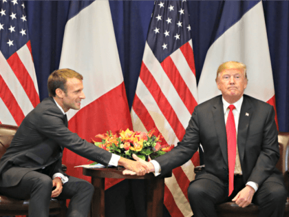 TOPSHOT - French President Emmanuel Macron (L) shakes hands with US President Donald Trump