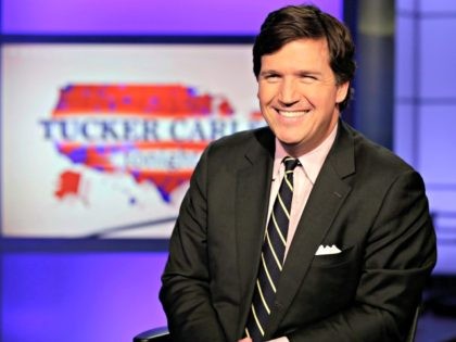 Tucker Carlson, host of "Tucker Carlson Tonight," poses for photos in a Fox News Channel s