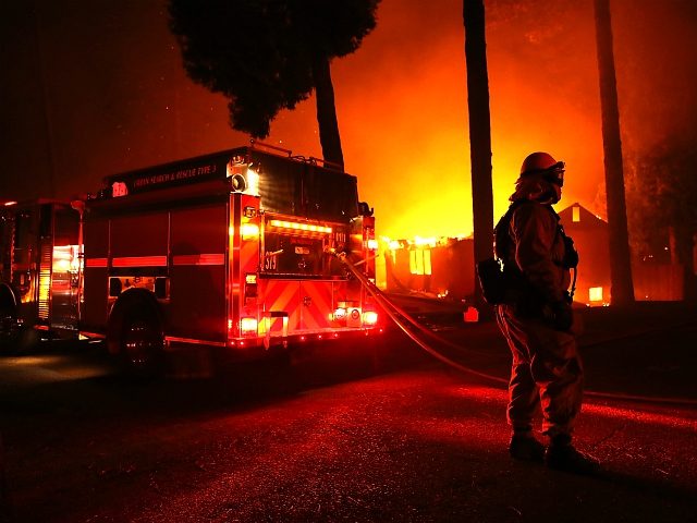 PARADISE, CA - NOVEMBER 08: Firefighters try to save a building as the Camp Fire moves through the area on November 8, 2018 in Paradise, California. Fueled by high winds and low humidity, the rapidly spreading wildfire has ripped through the town of Paradise, charring 18,000 acres and destroying dozens …